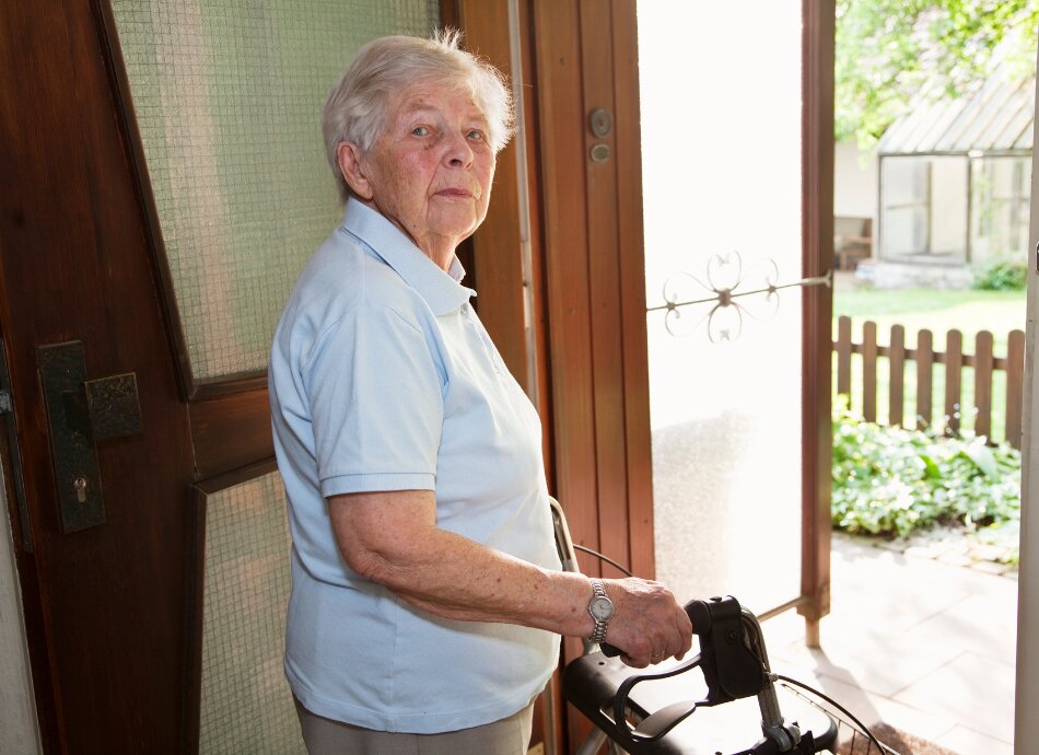 Elderly woman leaving house using her walker
