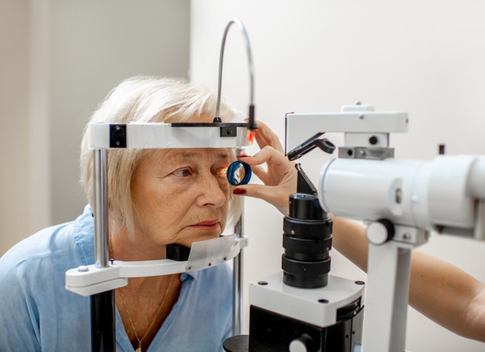 Older woman leaning forward to have eye examination