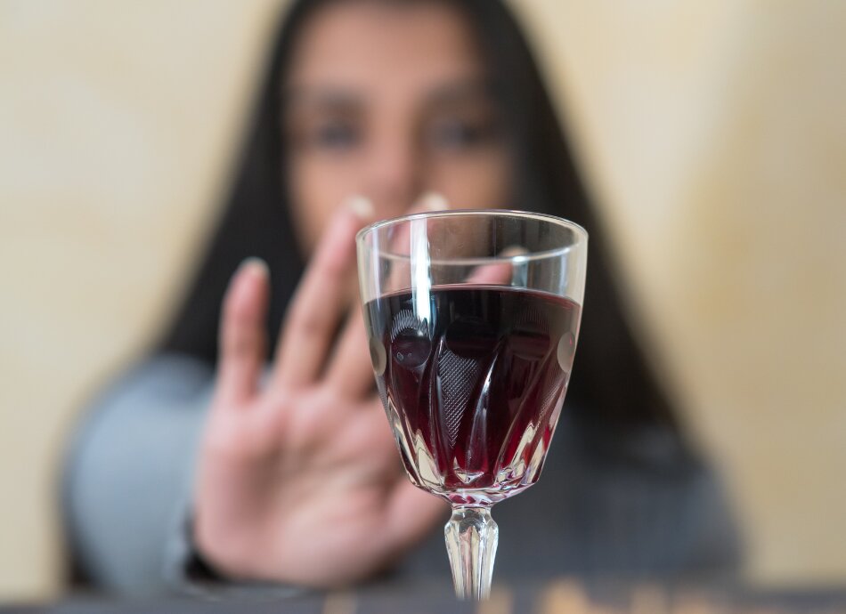 Woman refusing glass of red wine