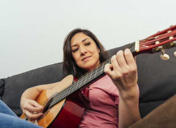 Young adult female playing guitar