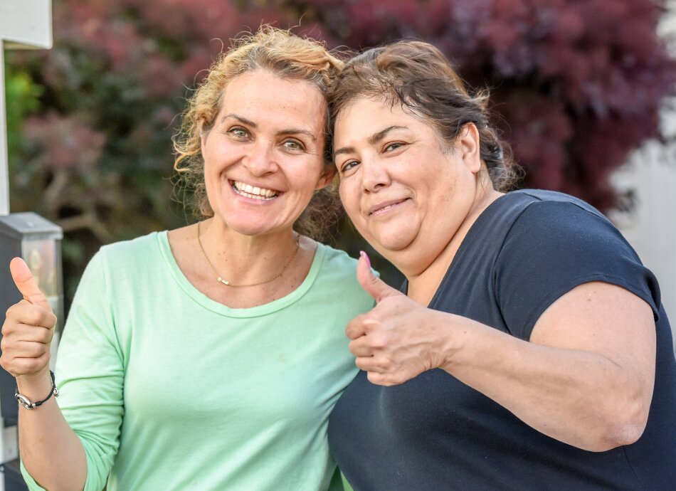 Two women giving thumbs up