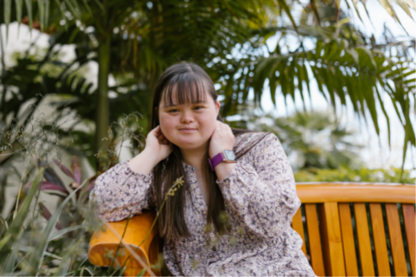 Young woman with Down syndrome sitting on bench