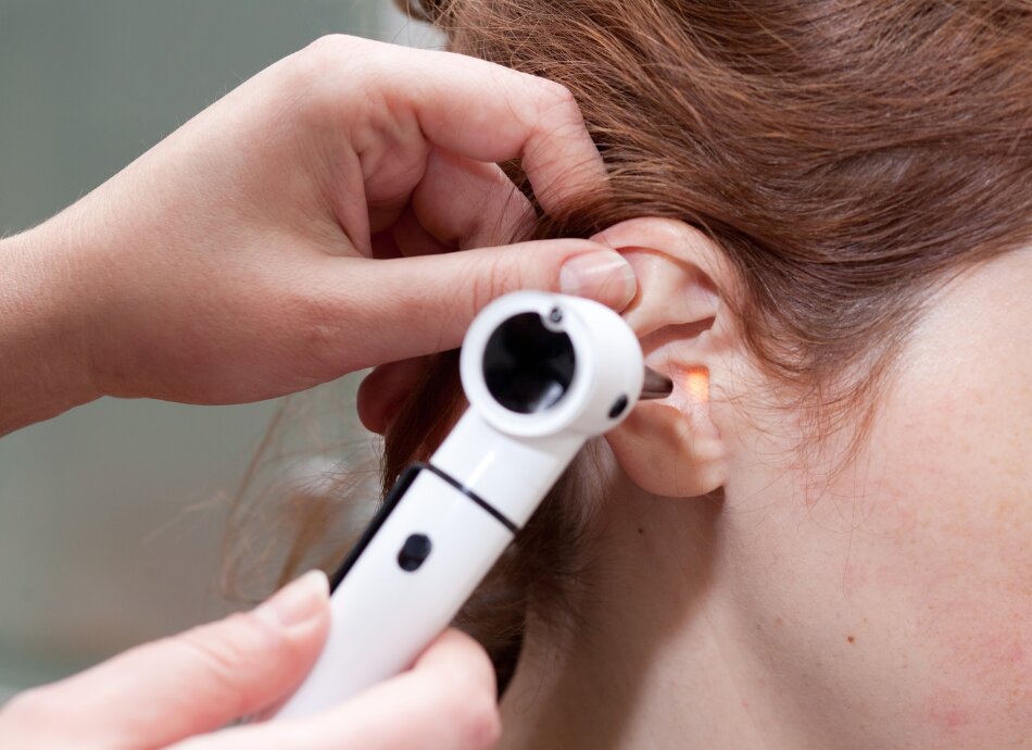 Child's right ear being checked with an otoscope