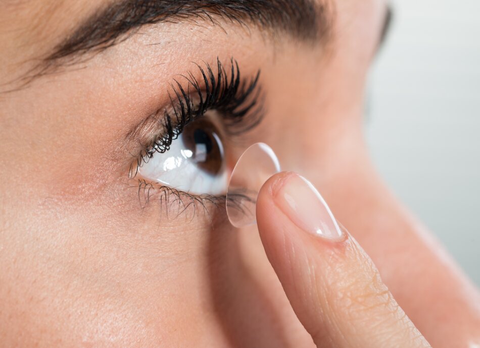 Woman about to put contact lens into right eye