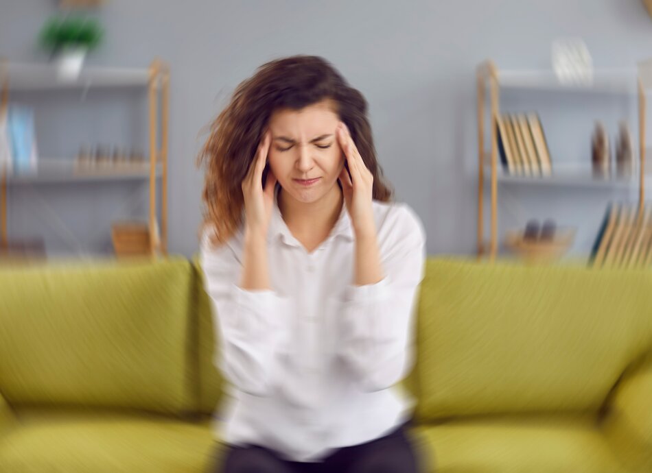 Woman sitting feeling dizzy with blurred surroundings