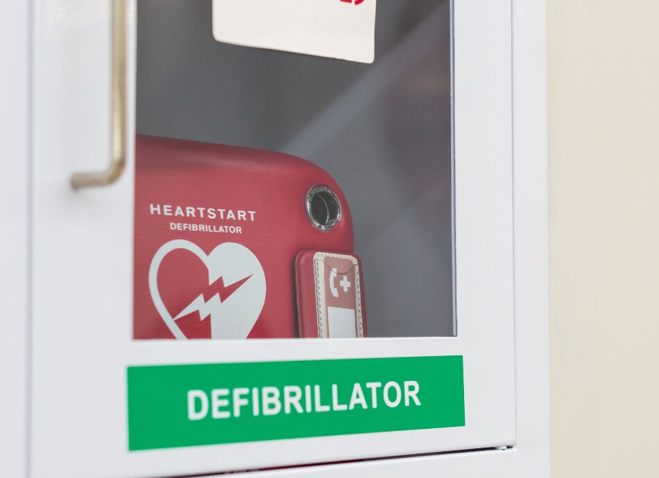 AED defibrillator in glass-fronted cupboard