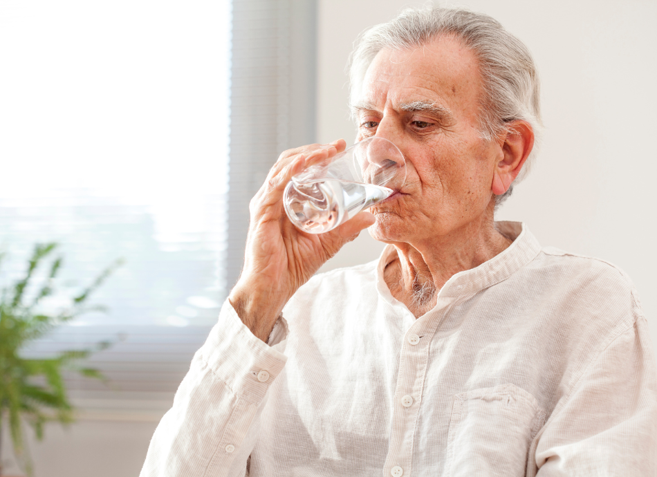 Older man drinking a glass of water