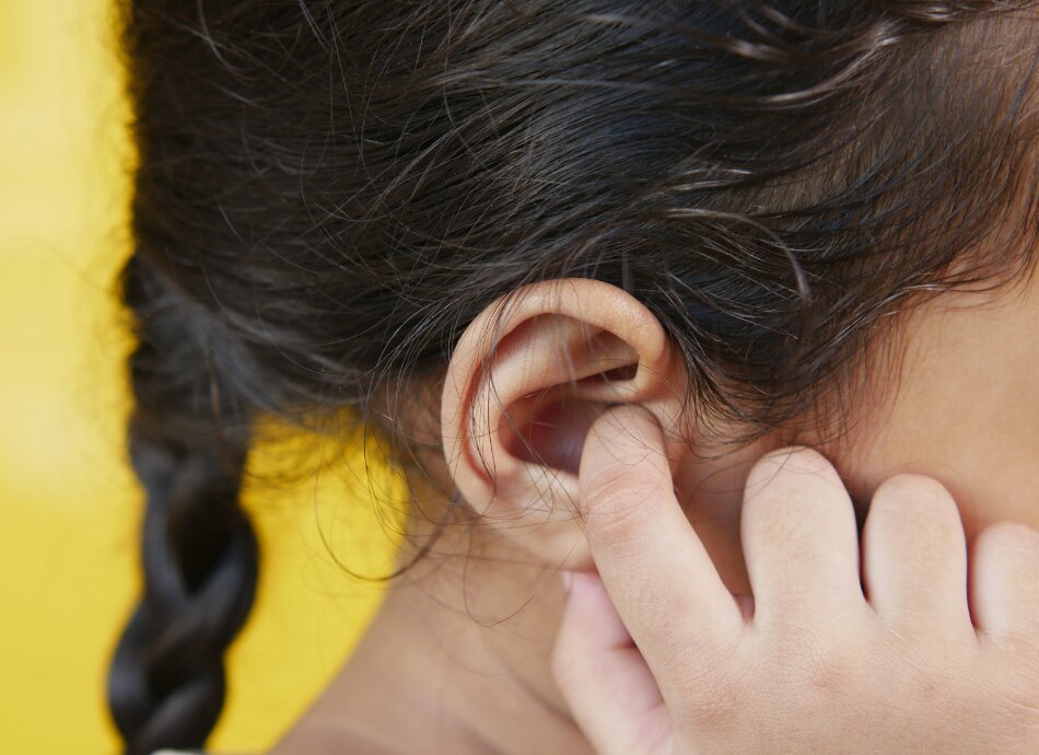 Young girl with finger in her right ear
