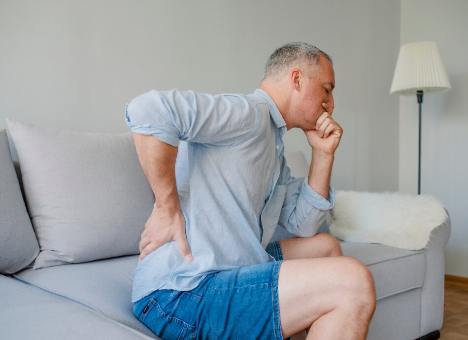 Man on couch with kidney pain and nausea