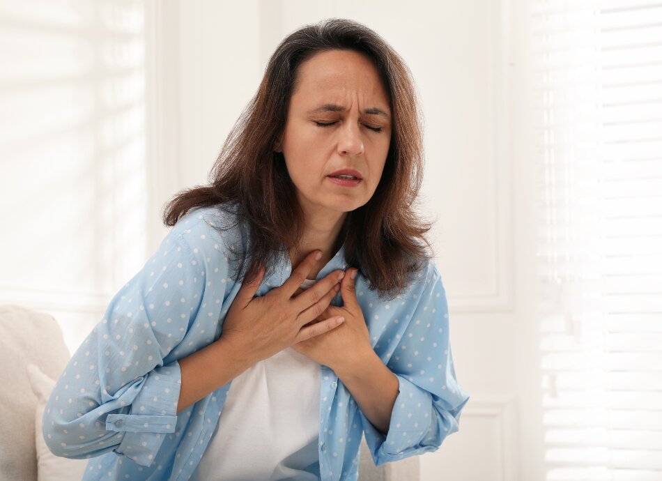 Woman clutching chest with breathing problem or pain