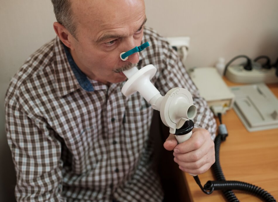 Senior man taking a spirometry or breathing test