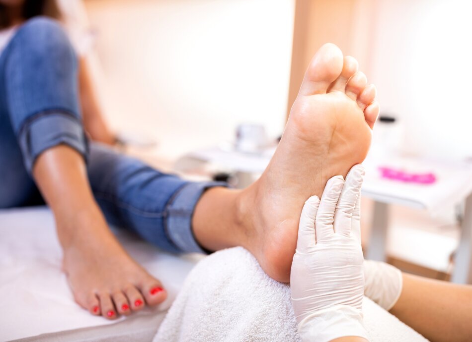 Foot being examined by person wearing gloves