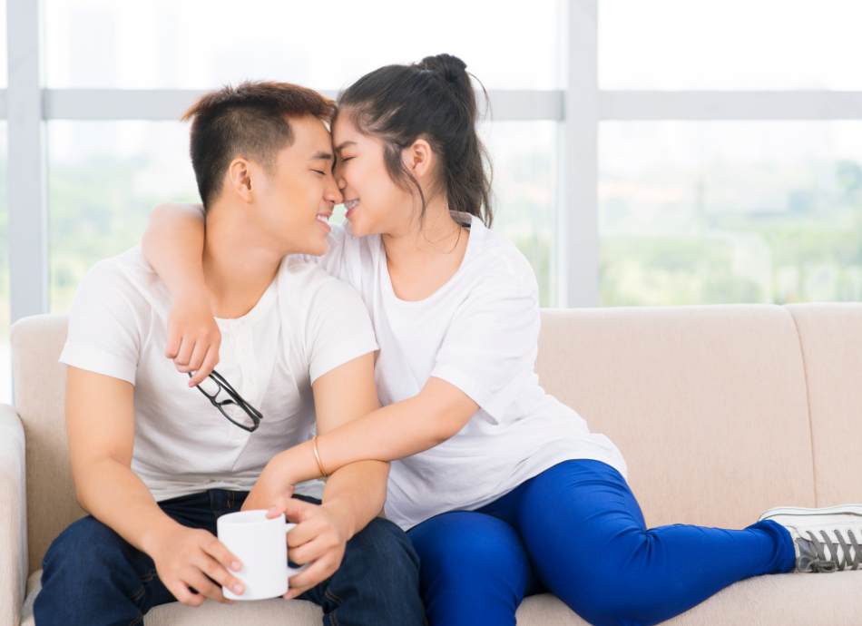 young couple cuddling on couch