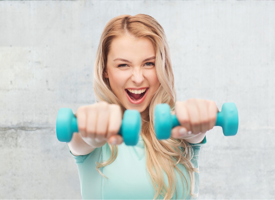 Smiling strong young woman with hand weights