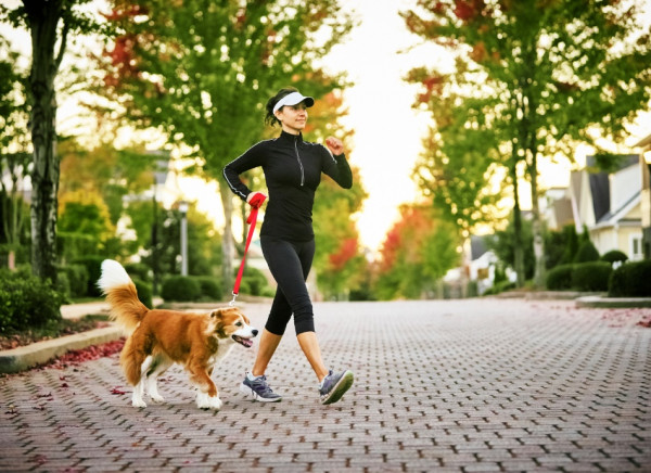 Woman walking dog and wearing sun protective clothing