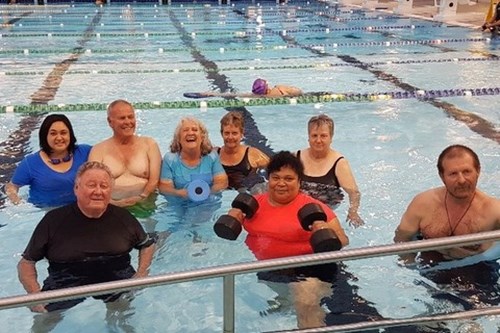 Several people standing in a swimming pool