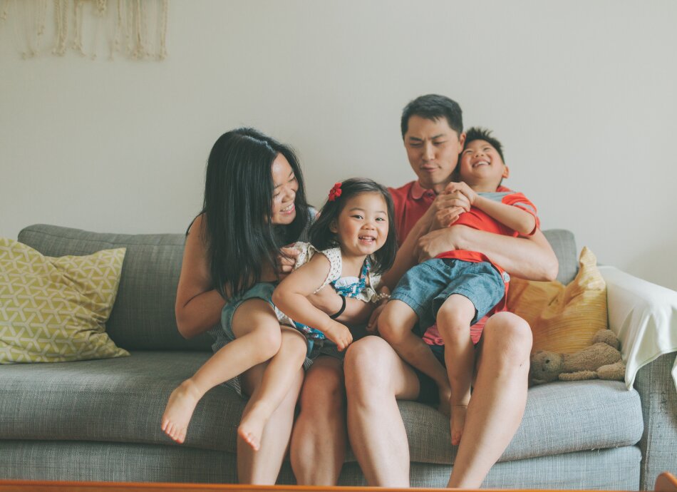 Asian family sitting on couch 