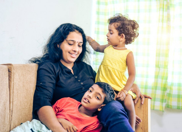 Indian woman with two children sitting on a couch