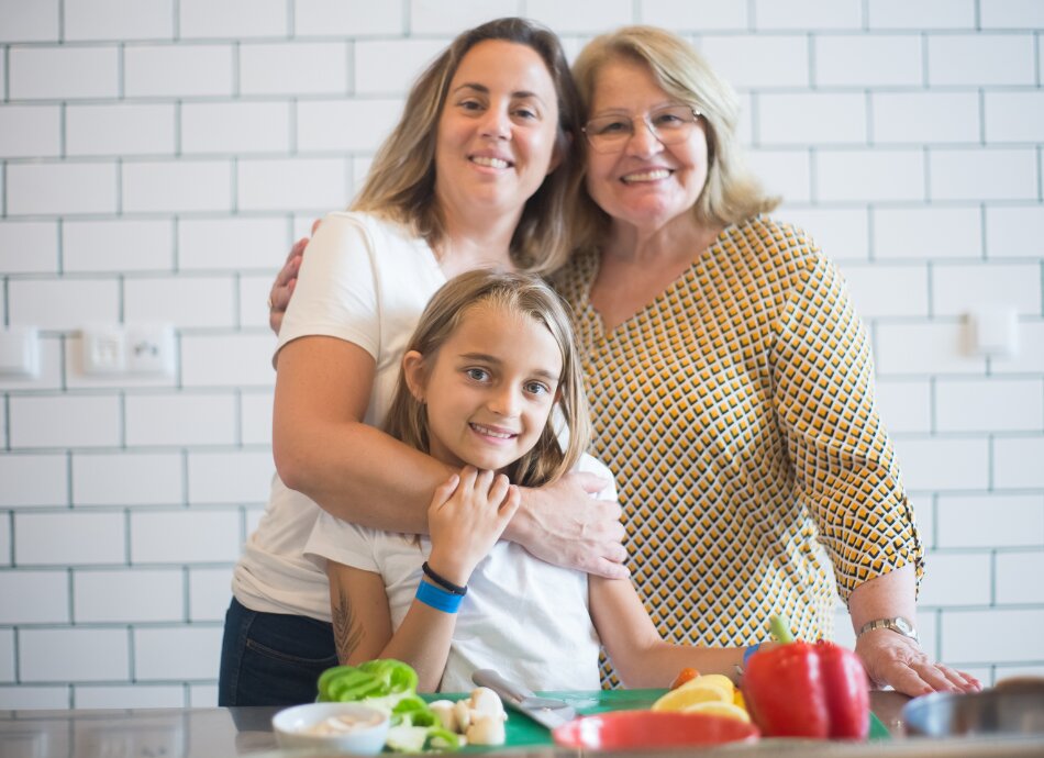 Three generations of smiling women in kitchen