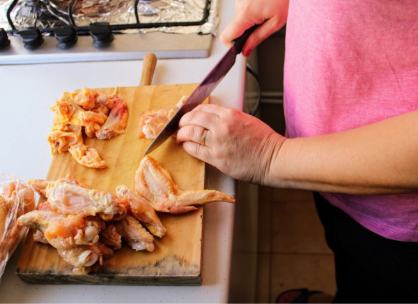 Chicken being chopped up on wooden board