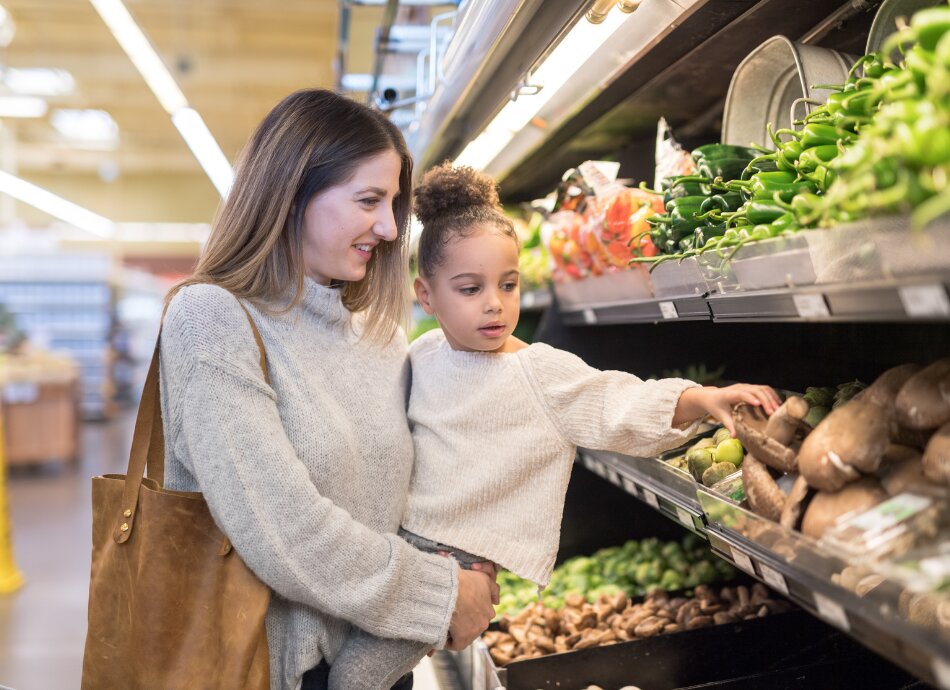 Mother and daughter chose groceries at supermarket