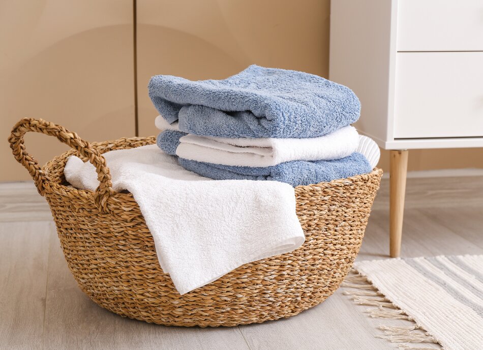 Towels in laundry basket canva 950x690