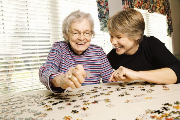 Senior woman and younger woman doing a jigsaw puzzle