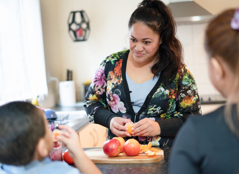 Young Māori mum preparing fruit for children