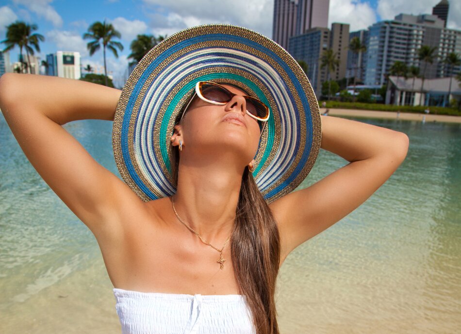woman in the sun wearing straw hat Canva