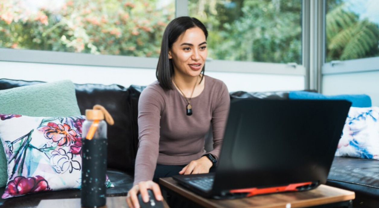 Māori wahine working online from the couch