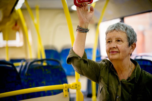Older woman standing on bus